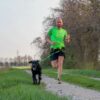 Uomo che corre con il cane utilizzando la Linea CaniX con la pettorina X Run e la cintura Racing